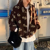 Person wearing a brown floral-patterned jacket in front of a metallic background